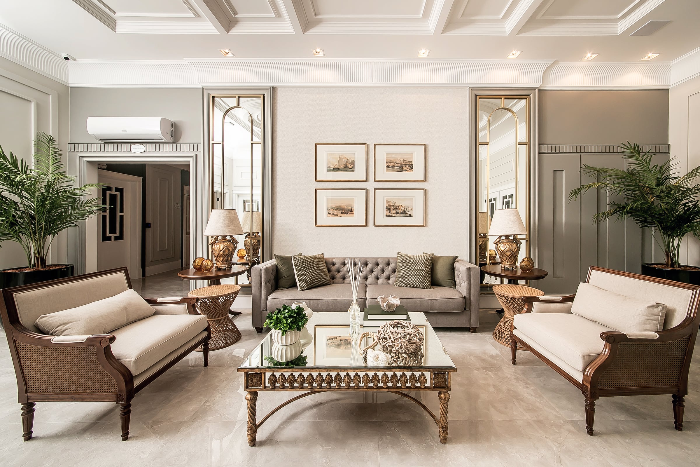 Lounge de recepção do Noah, com poltronas de vime, sofá estofado e espelhos emoldurados em dourado